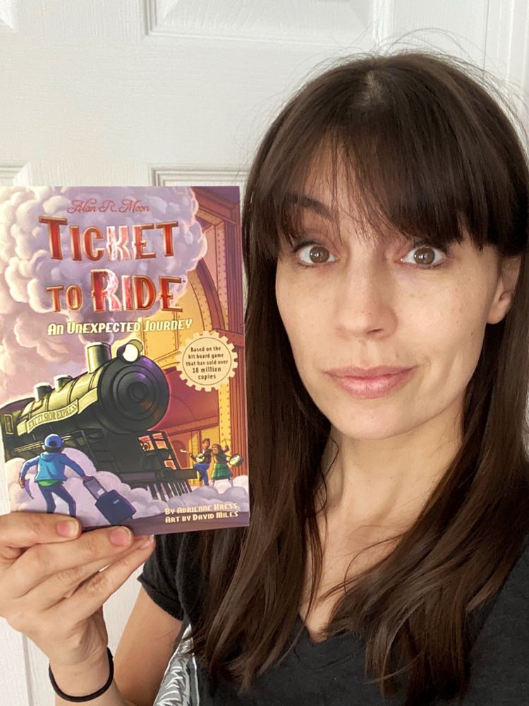 Me holding a copy of TICKET TO RIDE: AN UNEXPECTED JOURNEY! 