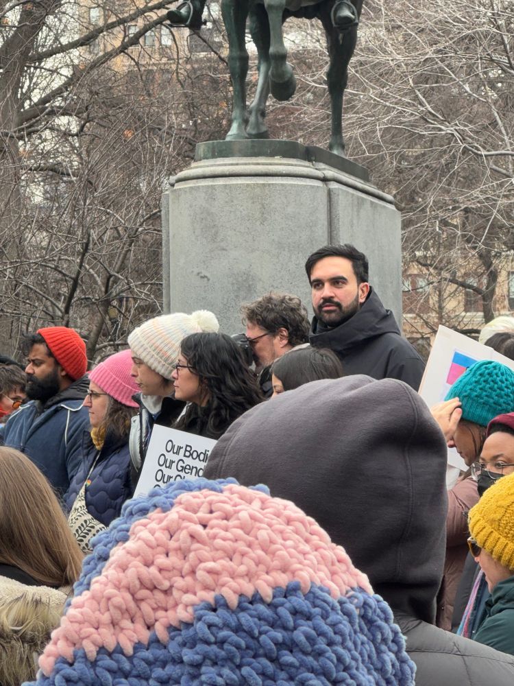 Zohran standing amidst a crowd in winter clothing