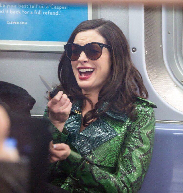 Queen of Genovia, Amelia Mignonette Thermopolis Renaldi (it's Anne Hathaway), laughing while riding the subway with a knife in hand 