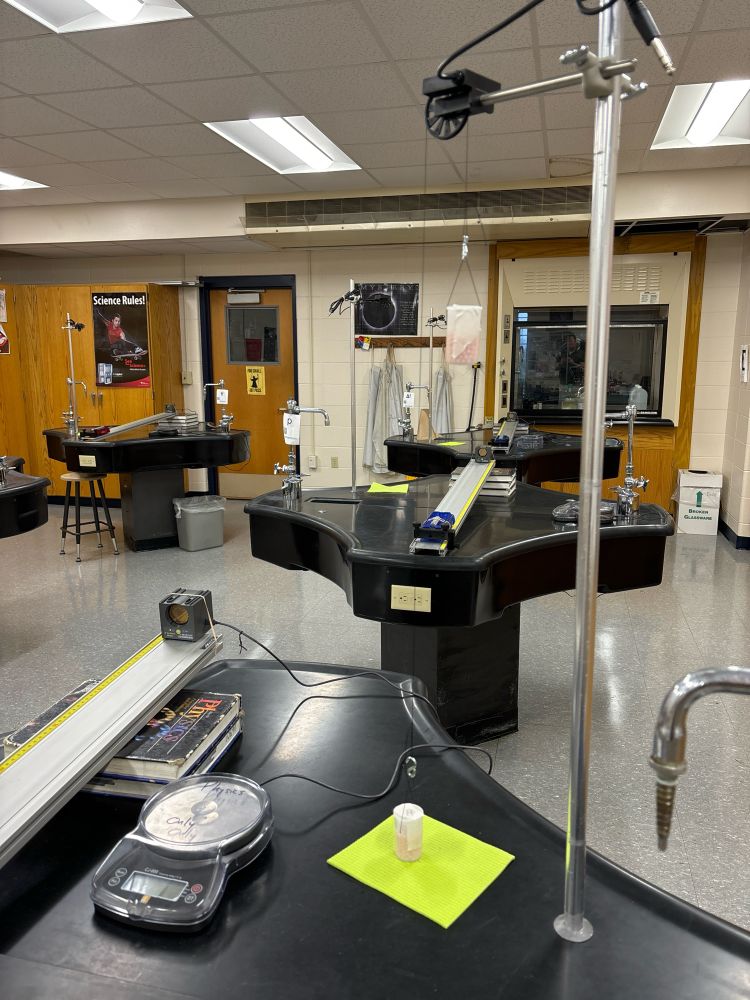 Two film canisters hang from a pulley at rest. 