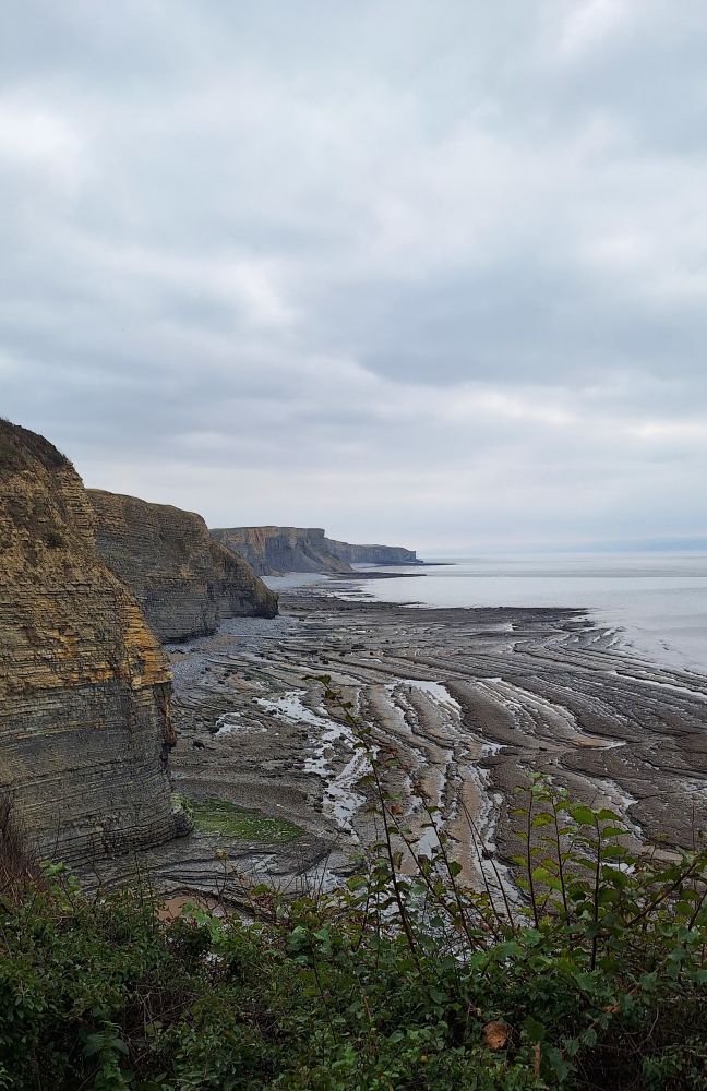 View across to Llantwit beach. Grey skies with the tide out and you can sea the shore platforms 