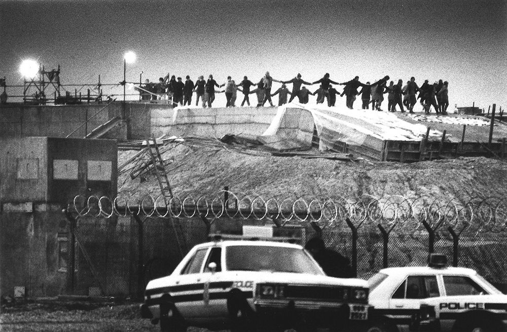 Protesters at Greenham Common dance on the nuclear missile silos at the air base on New Year's Day, 1983. Photograph taken by Raissa Page. Richard Burton Archives, Swansea University.