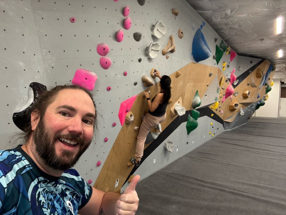 Selfie of Burton at the climbing gym, bouldering wall in the background.

Fans of Valve’s DOTA2 might notice Burton is rocking a referee jersey from The International 2023 that took place at Seattle’s Climate Pledge Arena in October 2023
