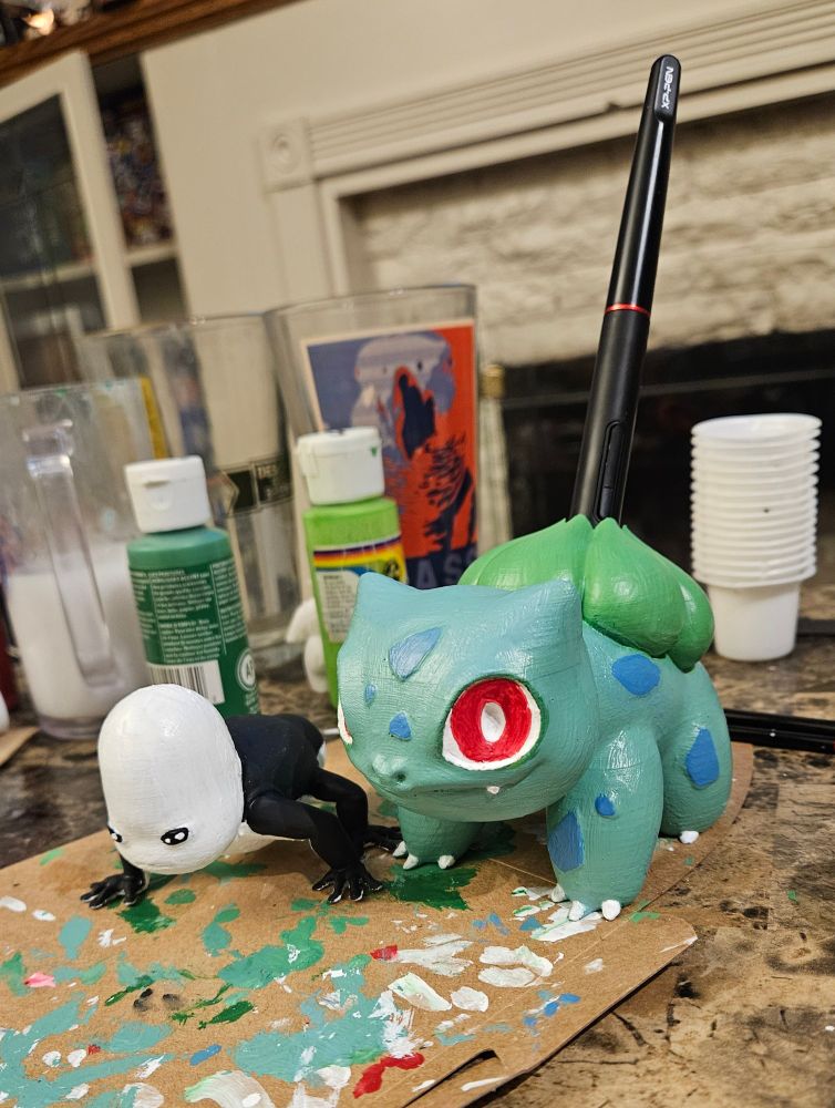 3D printed "hollow" creature from scavengers reign and a bulbasaur tablet pen holder painted with acrylics.