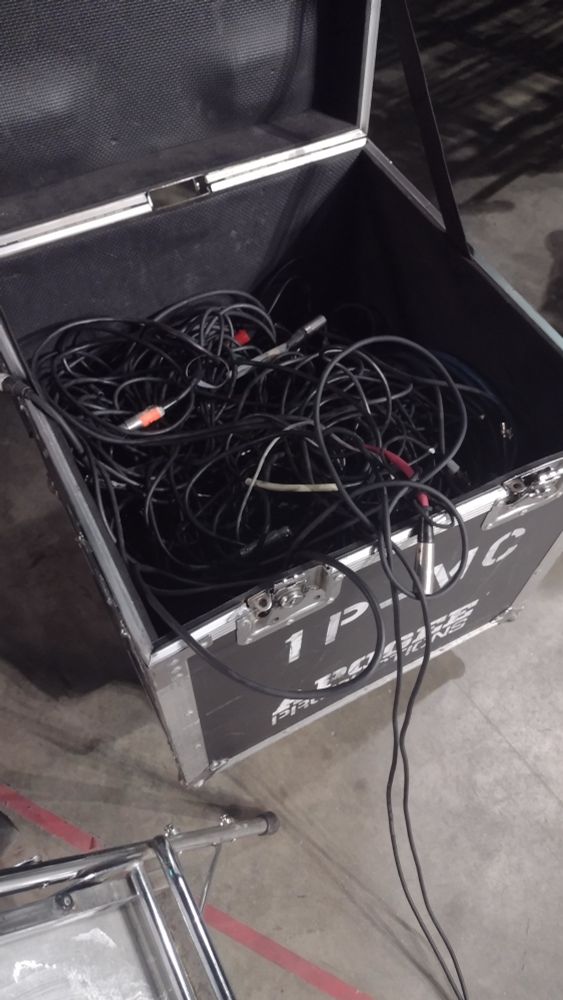 An extremely messy road case full of tangled xlr cable
