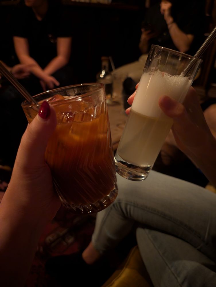 Two cocktails. One is red and the other is really light and clear with a white mousse on it.