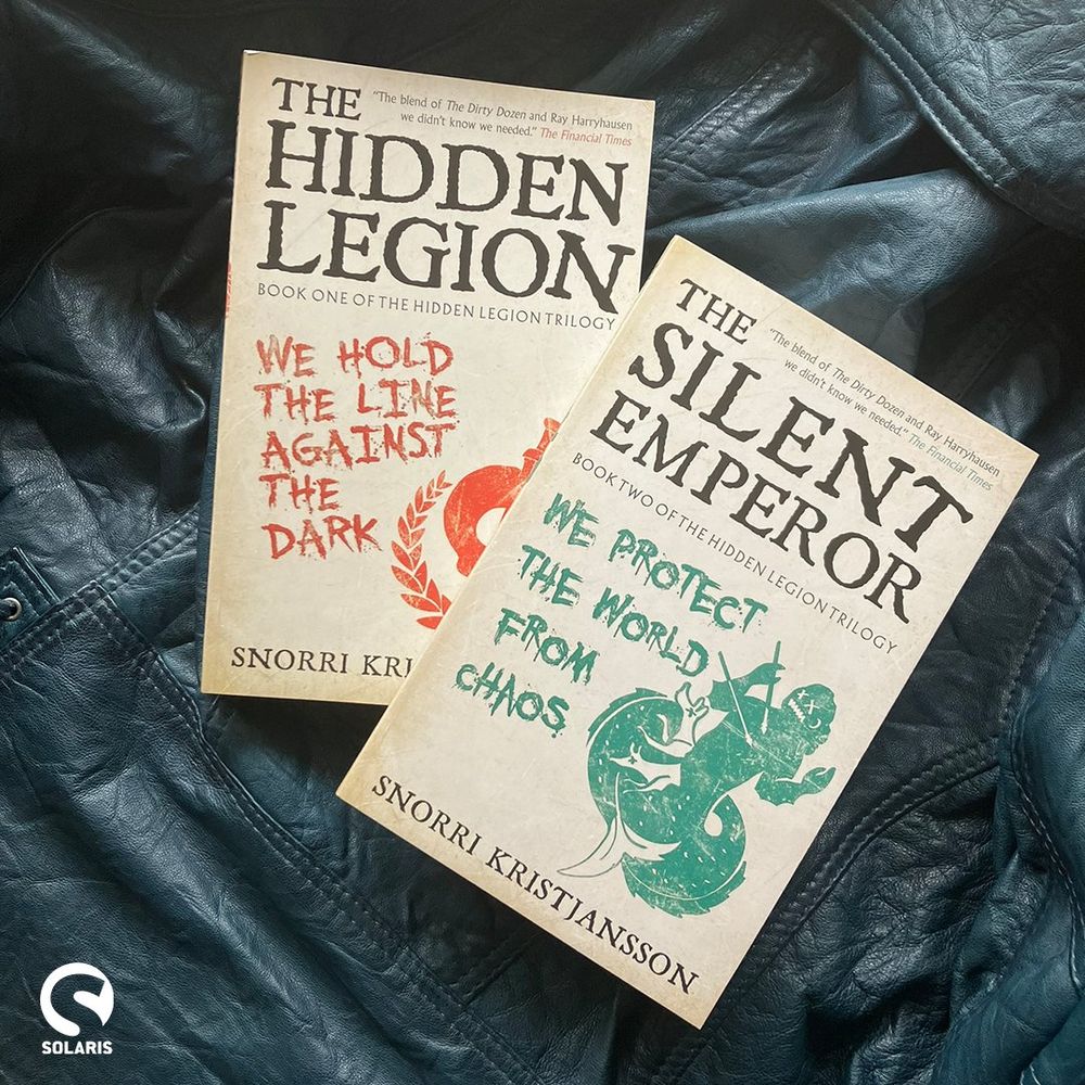Two paperbacks from THE HIDDEN LEGION series against teal leather.