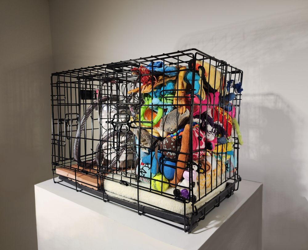 This image is of the same sculpture but from a side angle, showing more of the dog toys.
