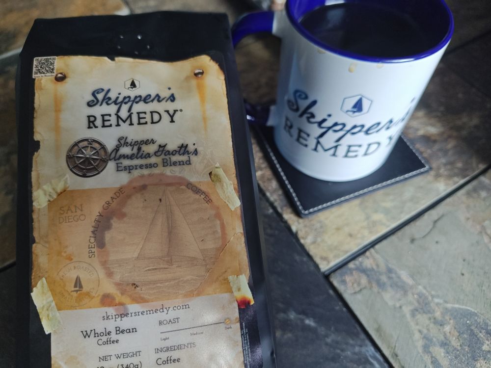 A bag of Skipper Amelia Gaoth's Espresso Blend specialty grade coffee and a coffee mug from Skipper's Remedy®