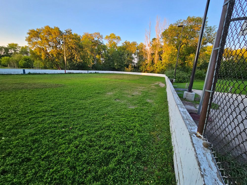 outdoor skating rink in late summer, bottom green with vegetation