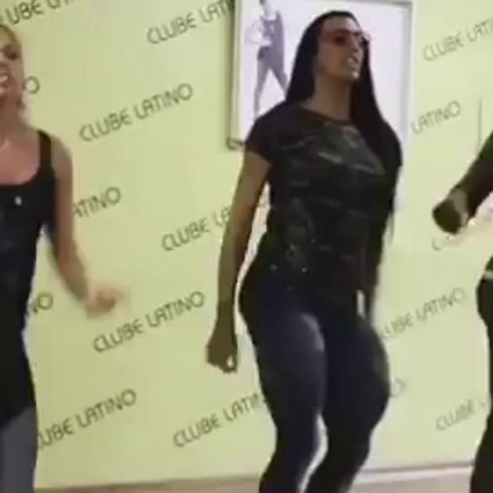 a group of women are dancing in front of a wall that says clube latino