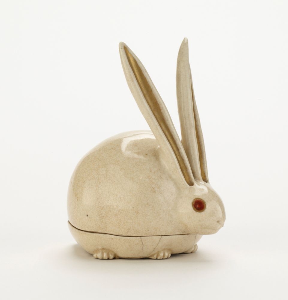 official museum photo, side profile on white background
Incense box in form of crouching albino rabbit (white with red eyes); very round body and very long erect ears
additional info:
Clay: hard, fine, grayish-white.
Glaze: luminous cream, crackled; touches of coral-red and gilding.
Mark impressed on base.