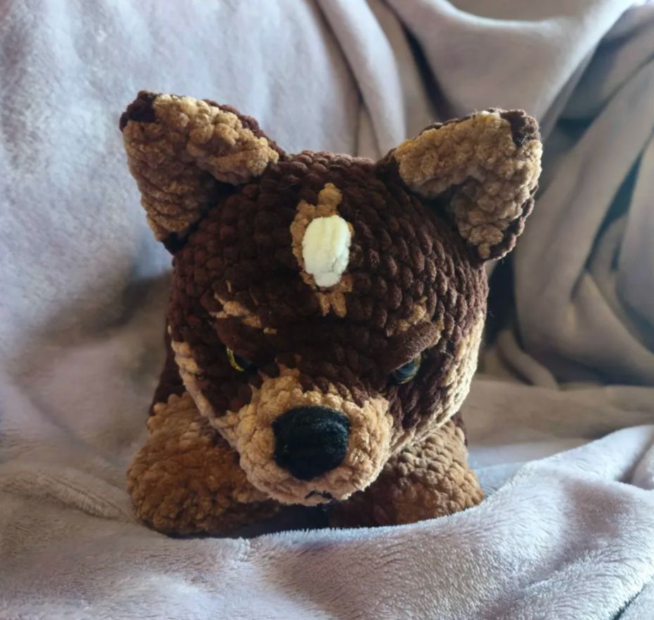 A front view of Gaius as a wolf pup plush. He looks very grumpy.