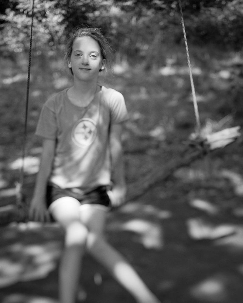 Portrait of a girl on a swing in the woods.