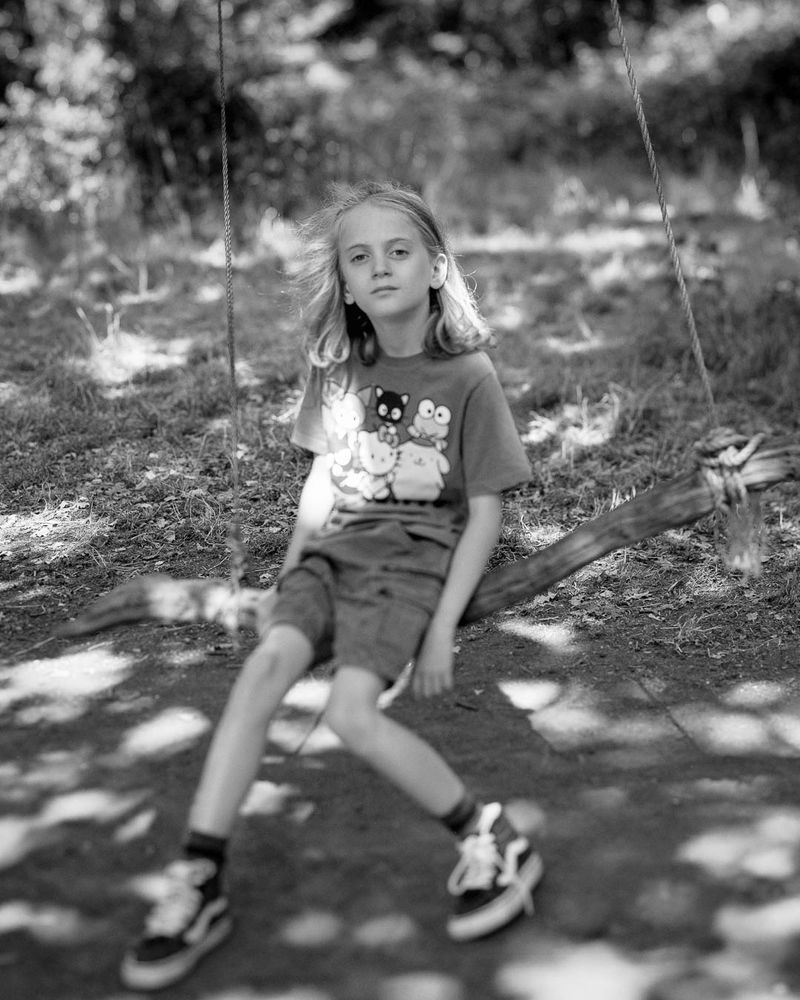 Portrait of a boy on a swing in the woods.