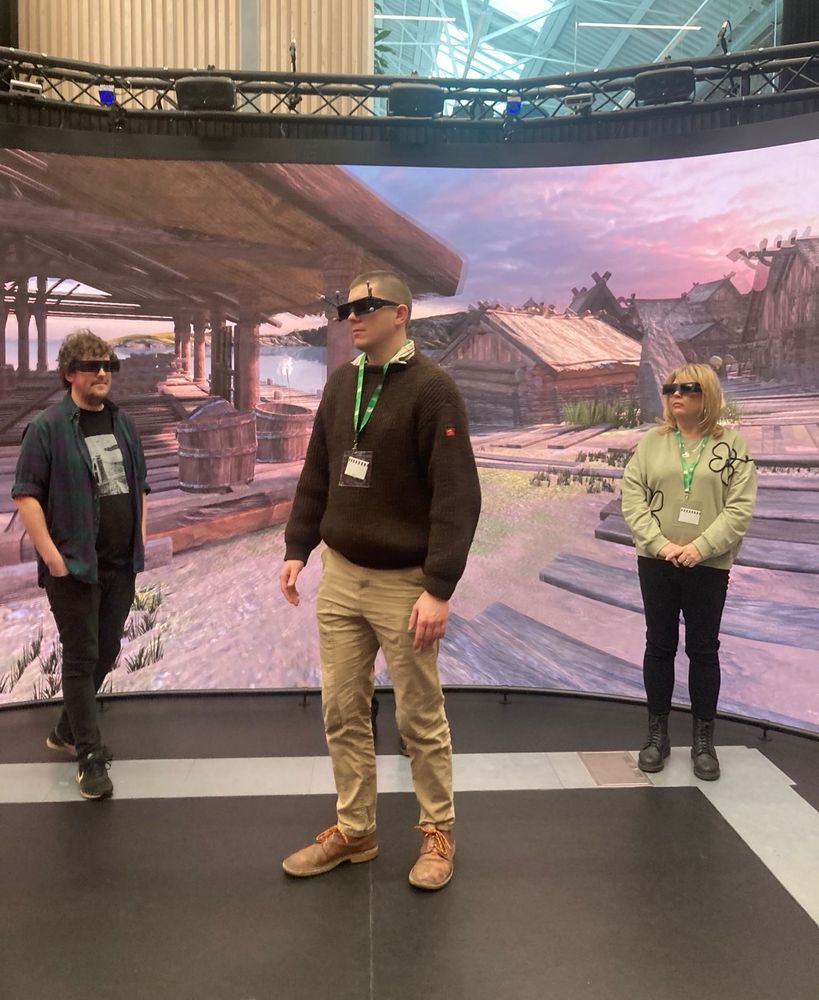 People standing in BDFI’s Reality Emulator  - an interactive wrap-around digital space.