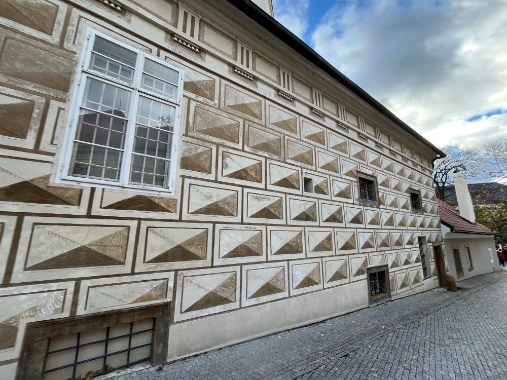A wall with rectangles with four colored triangles in it creating a geometric pattern that makes the windows hard to see. Photo by Robert Emond. 