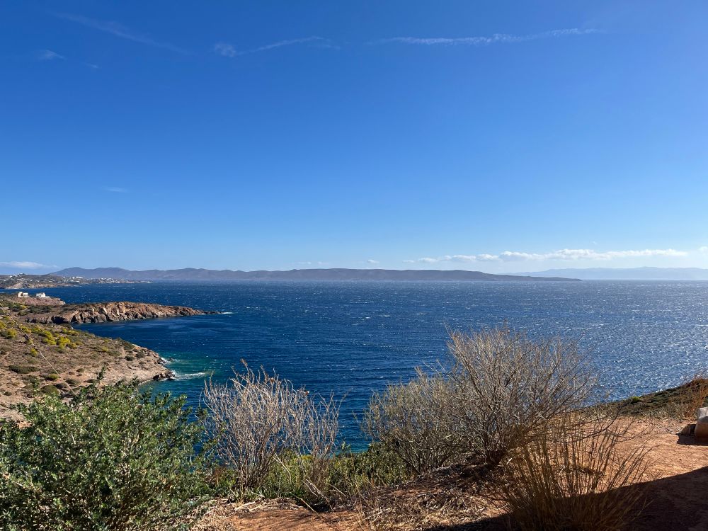 A panoramic view of the Adriatic from the temple of Poseidon. The water sparkles and the sky runs from deep sky blue to light sky blue in a lovely ombré effect. Photo by Robert Emond 