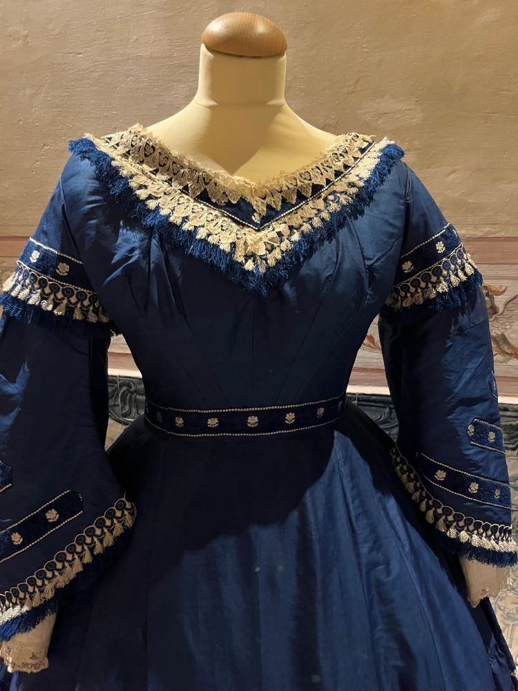A blue 1860s dress with lace and tassels as trim. Photo by Robert Emond. 