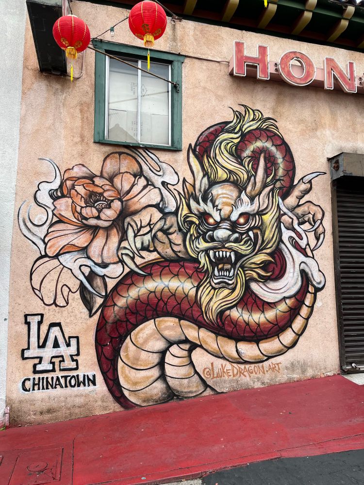 A mural of a Chinese dragon with “LA Chinatown” written next to it. The “LA” is stylized like the Dodger logo where the lower part of the “L” makes the horizontal line in the “A”. Photo by Robert Emond