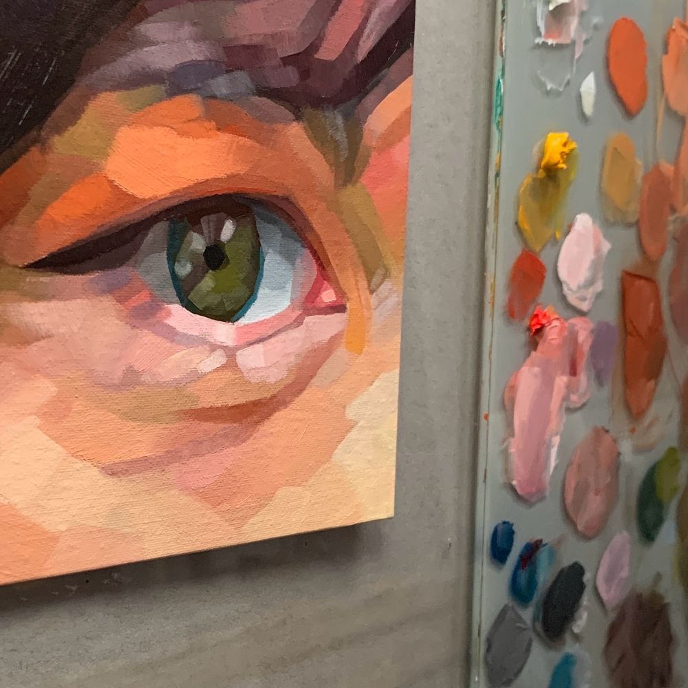 Cropped image of an oil painting of an eye beside a paint palette. 