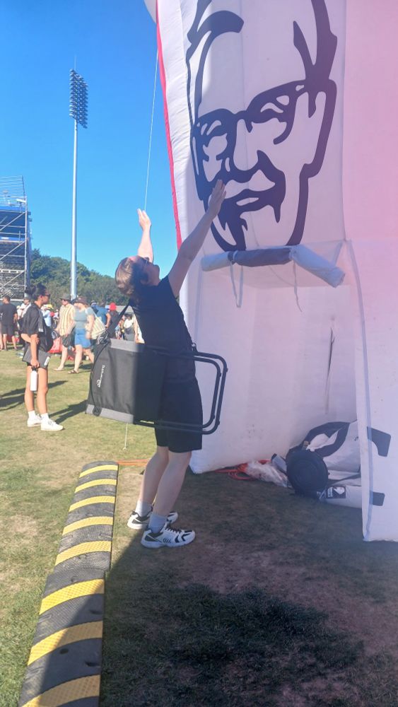 Ya gal after the cricket, giving worship to the giant inflatable KFC bucket at the game.