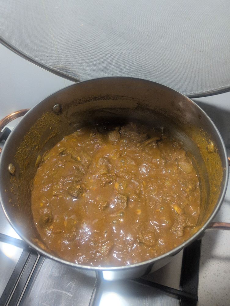 Beef curry in a pot cooking on stove