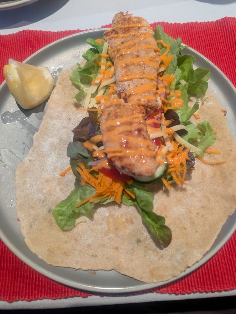 Crumbed chicken tender with sriracha mayo and salad on a wrap