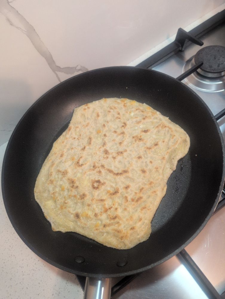 Wholemeal cheese and garlic naan in a black pan