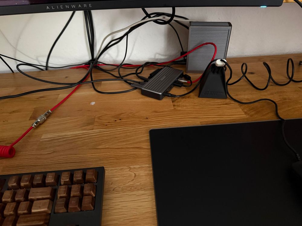 Cable mess with all peripherals connected to a cheap Anker Usbc hub. Useless CalDigit behind.