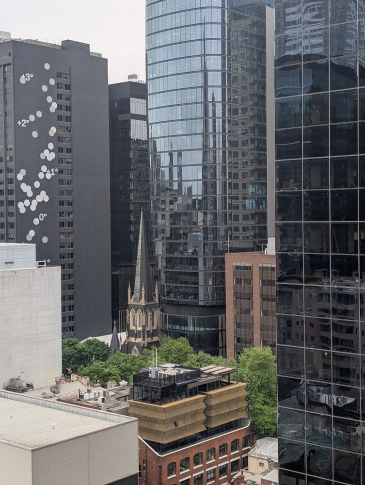 The spire of a church surrounded by skyscrapers 