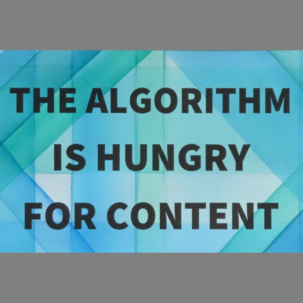blue and green overlapping watercolor stripes, with the words THE ALGORITHM IS HUNGRY FOR CONTENT in black 