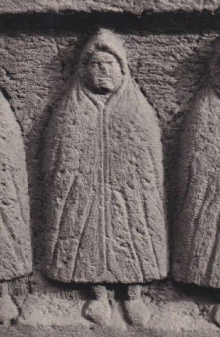 Stone carving of a figure in a hooded cape