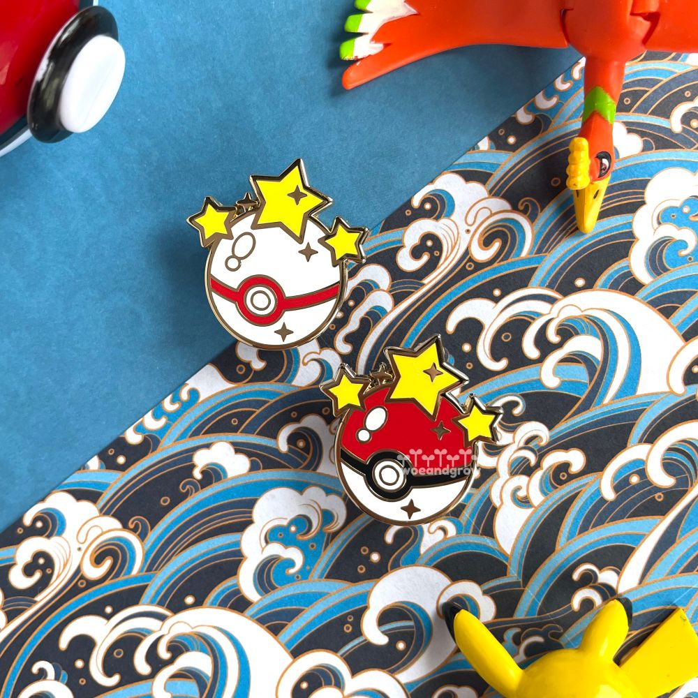 Photo of my Gotcha! Poké Ball and Premier Ball enamel pins on a wave patterned background surrounded by some Pokemon toys
