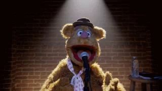 a teddy bear is singing into a microphone while wearing a tie .