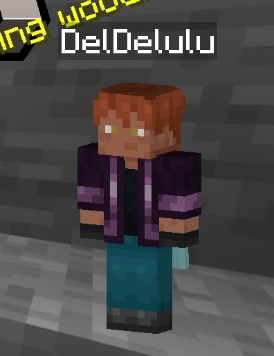 Uma skin do minecraft, de cabelo curto ruivo, pardo, olhos âmbar, camisa preta e moletom roxo, calça azul, tênis preto e luvas pretas.
