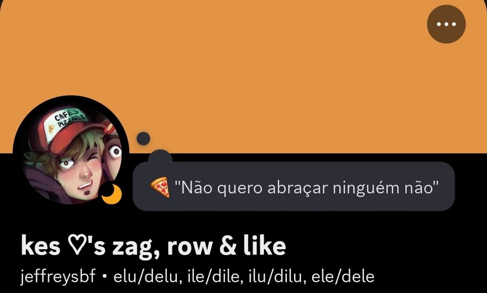 Print de um perfil do discord, com um retângulo laranja claro, no canto esquerdo, um círculo com uma fanart do Mike de Natal Macabro, ao lado um balão de pensamento escrito "🍕 'Não quero abraçar ninguém não'. Abaixo, em letras grandes e brancas, está escrito "Kes loves zag, row e like", e logo em baixo, menor, está "Jeffreysbf • elu/delu, ile/dile, ilu/dilu, ele/dele"