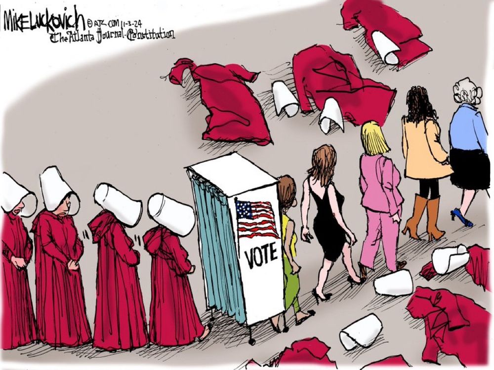 A cartoon reflecting women in red robes, hanging their heads under white caps, standing in line to enter a voting booth. On the other side of the voting booth women are exiting wearing heels and dresses and pant suits, having cast their handmaid’s tale garb aside, leaving them on the ground outside the voting booth 