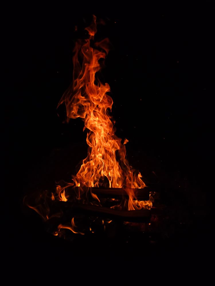 A roaring campfire against the black night sky