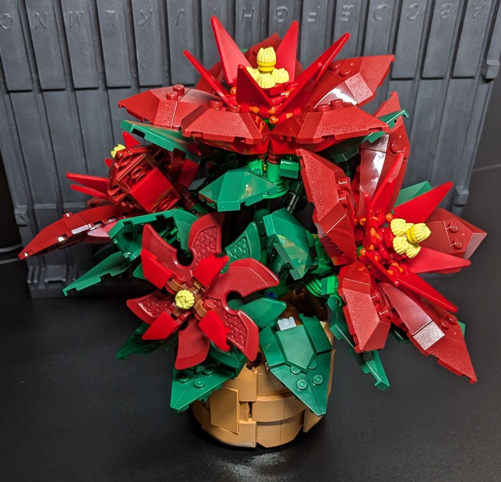 Lego Poinsettia - Red flowers with green leaves in a weaved pot.