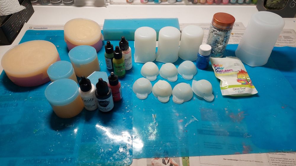 Molds, cups and inks set on a silicone mat waiting to be used