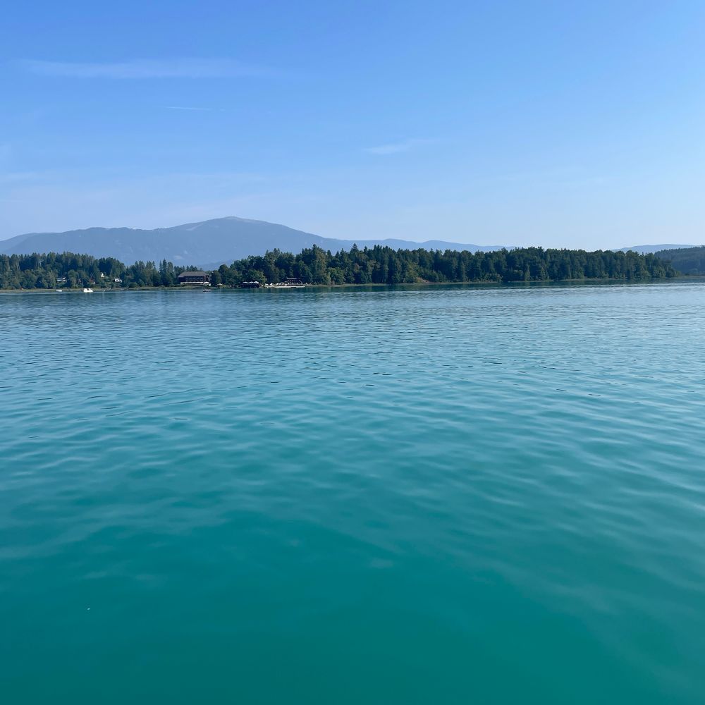 Sommertag am Faaker See in Kärnten. Türkisblaues Wasser und Wolkenloser Himmel 