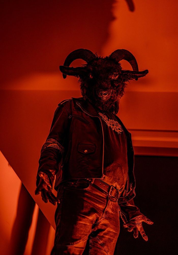 Wearing my fursuit head of Pazu, the satanic goat, leather jacket and other metal fashion clothes, standing in the hallway with red lighting for a more sinister look.