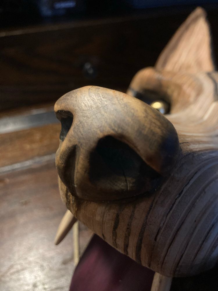 Close up of mask snout, carved from olive wood set upon beech