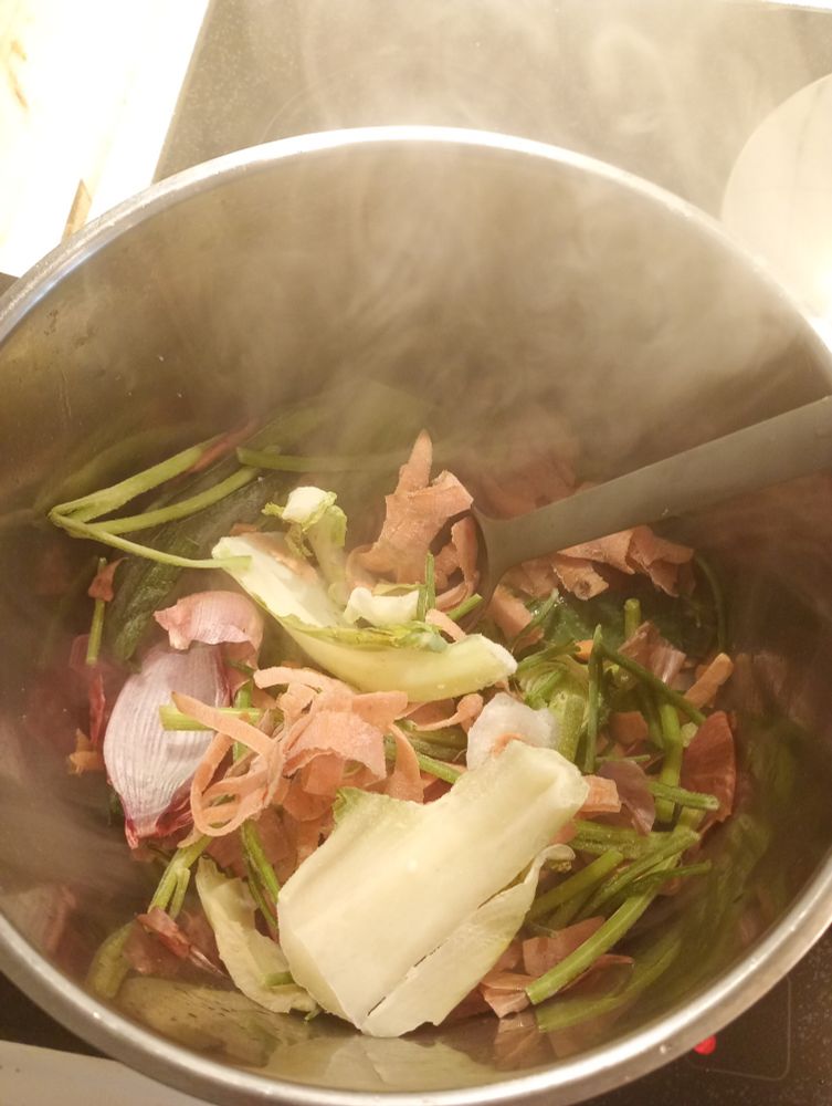 Kastrull med grönsaksrester som fräses inför buljongkok