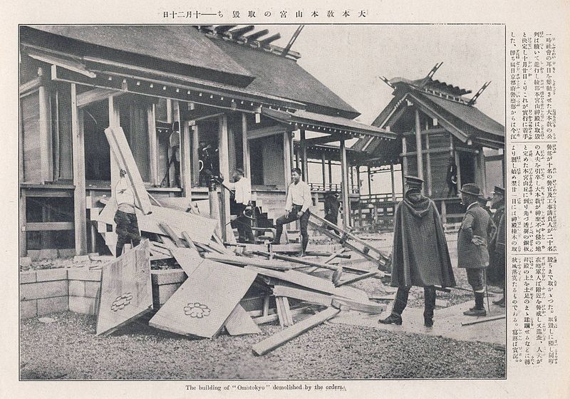 Fotografía de la demolición de la sede de Otomo. Se ven casas bajas y una pagoda. Varios operarios y guardias de capas largas observan