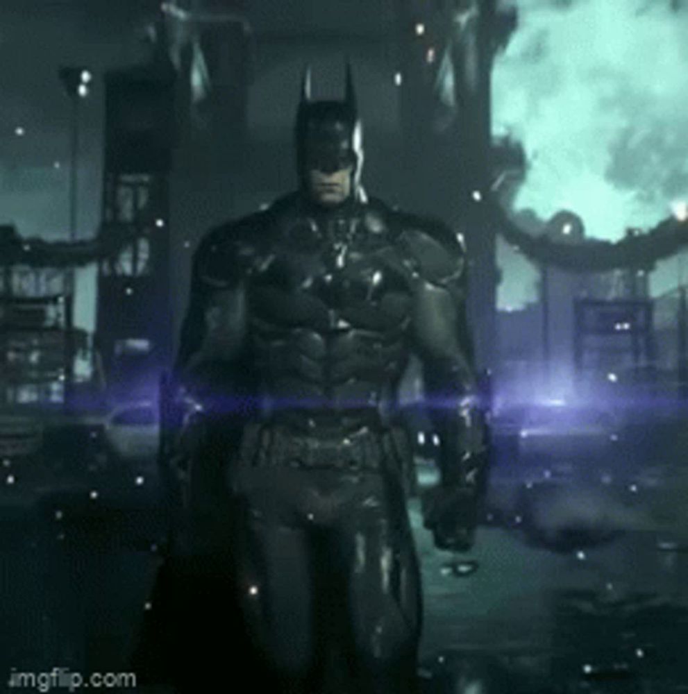 a man in a batman costume is standing in front of a burning building