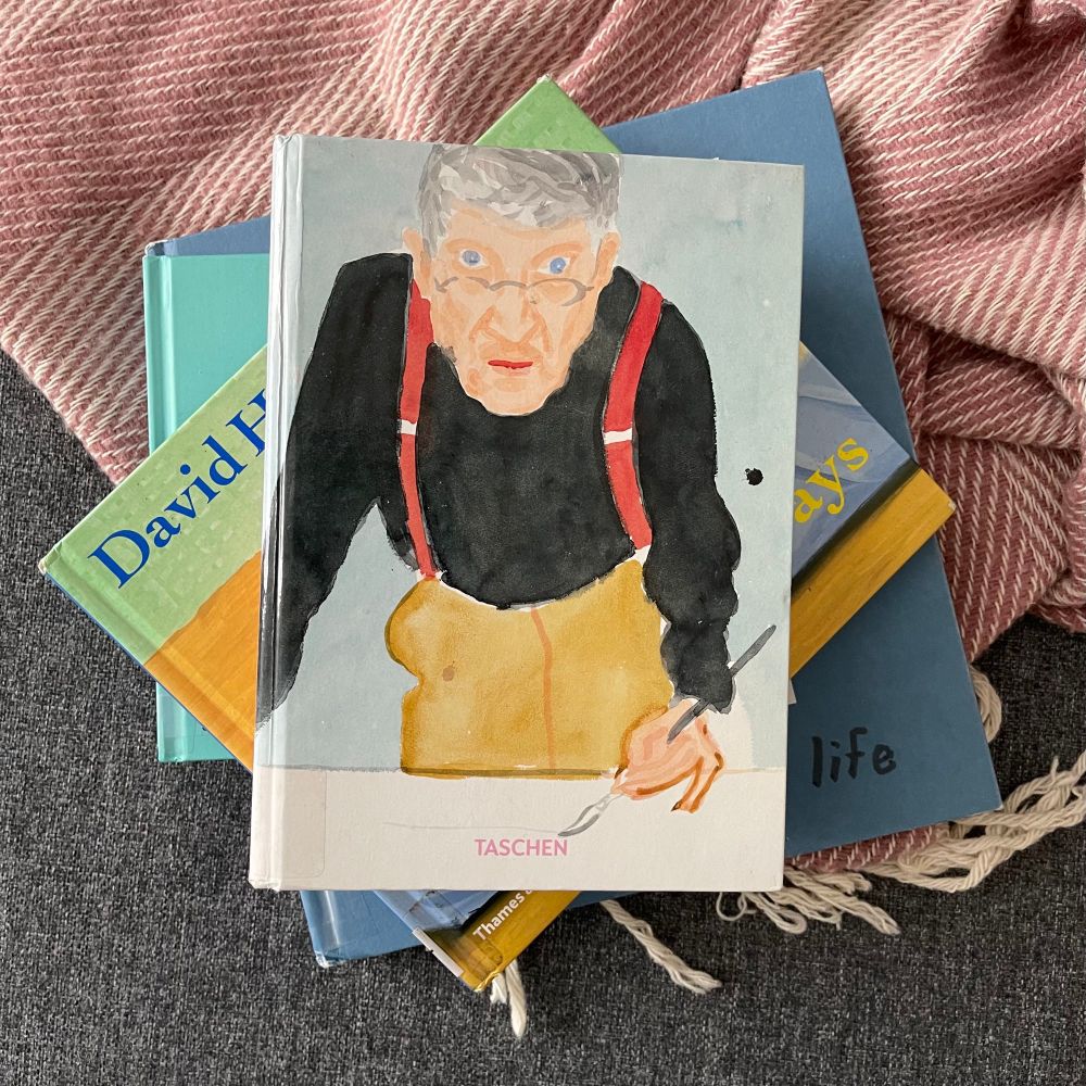 Stack of four books on David Hockney. Taschen edition on top has a self portrait on the cover, with the artist himself staring intently at the viewer.