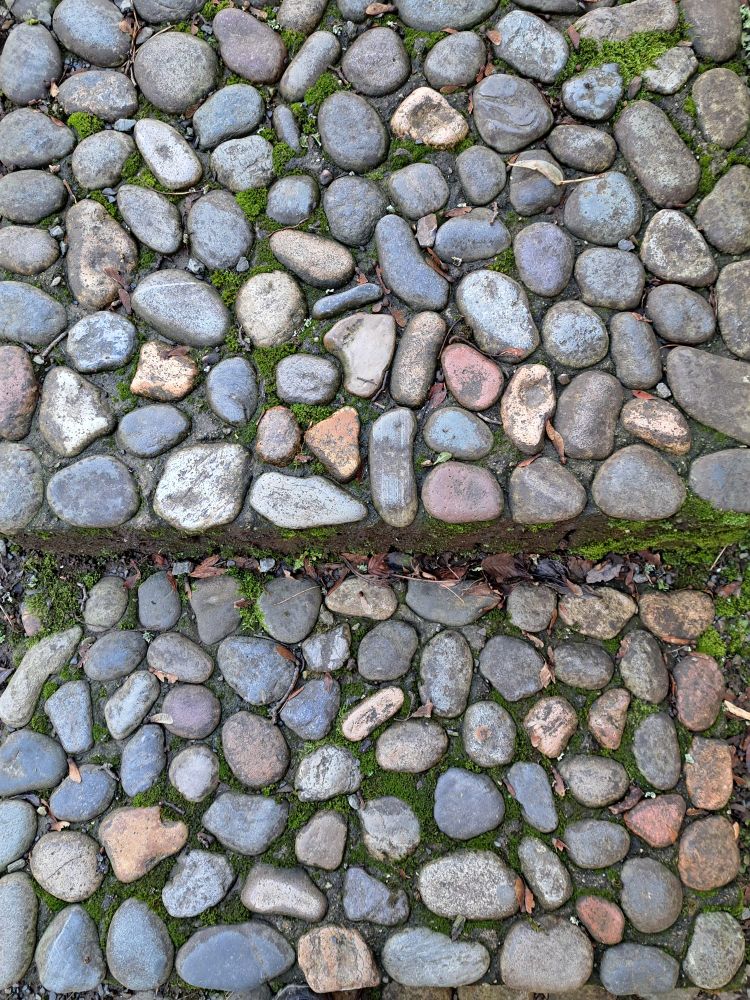 Different colored smooth cobbled stones in a path