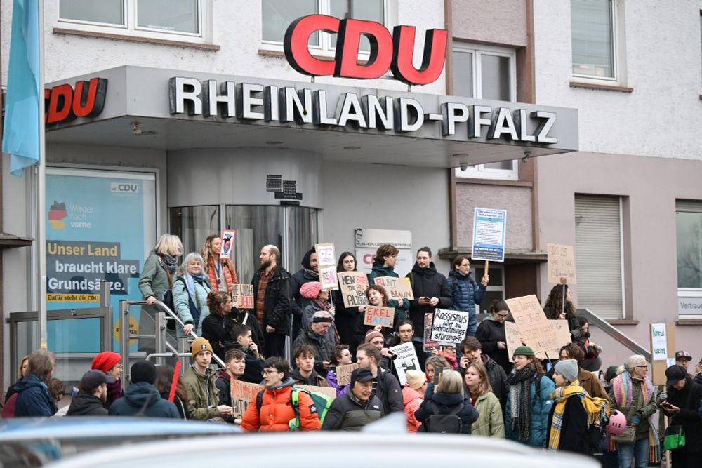 Demonstrierende stehen auf einer Treppe vor dem Haupteingang der CDU-Zentrale. Sie haben Schilder in der Hand.